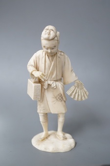 A Japanese carved ivory figure, Meiji period, of an actor, having a noh mask on the crown of his head and holding a fan, incised signature to base, height 16cm